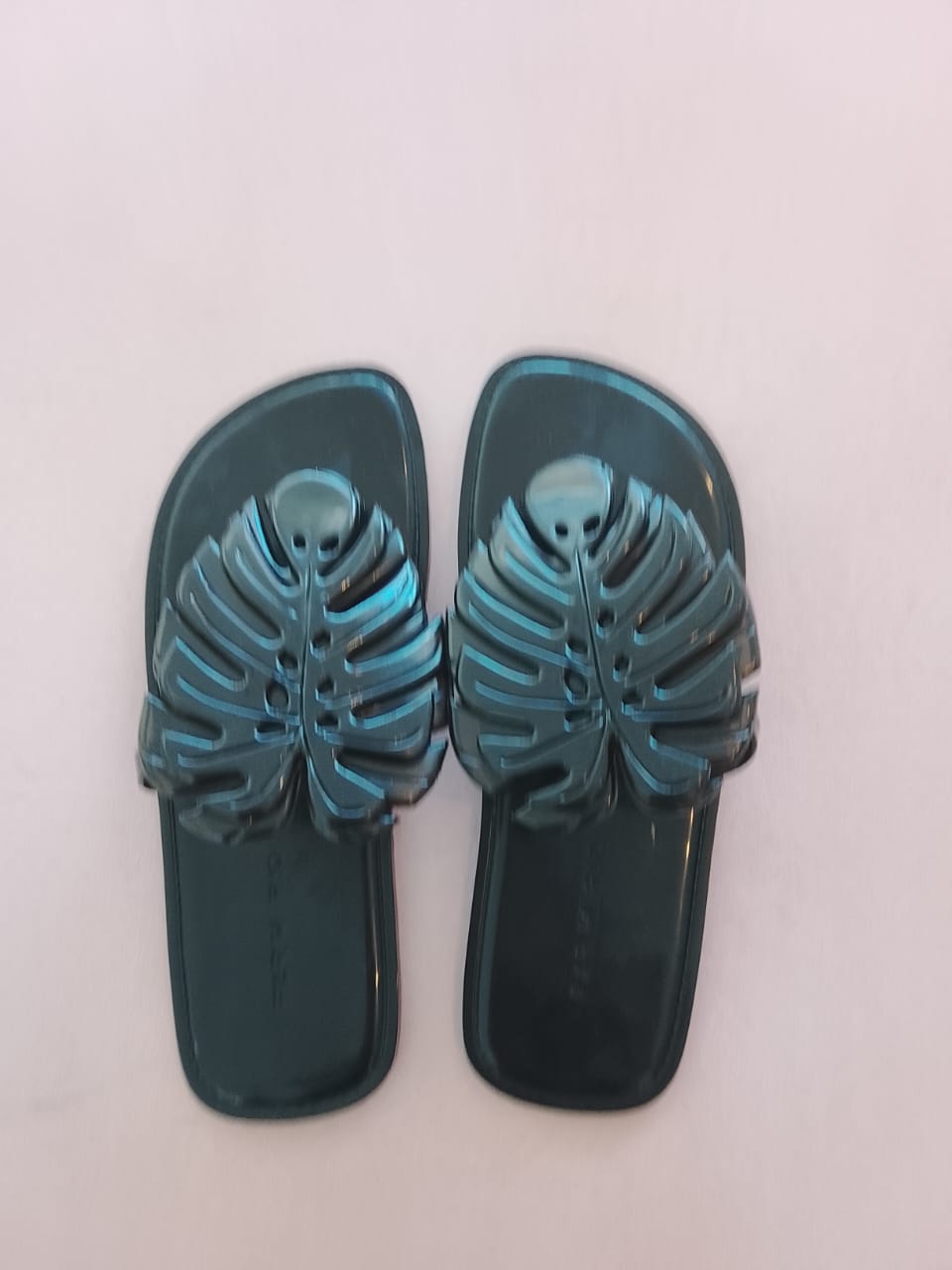 Sandália rasteira Jellys preta da Farm, com detalhes em plástico transparente e sola confortável, ideal para o verão.
