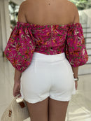 Cropped floral top by DELPHYNE with vibrant patterns and short sleeves, perfect for warm weather styling.