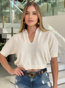 Textured Brenda blouse from ANIMALE displayed on a hanger, showcasing its unique fabric and elegant design.