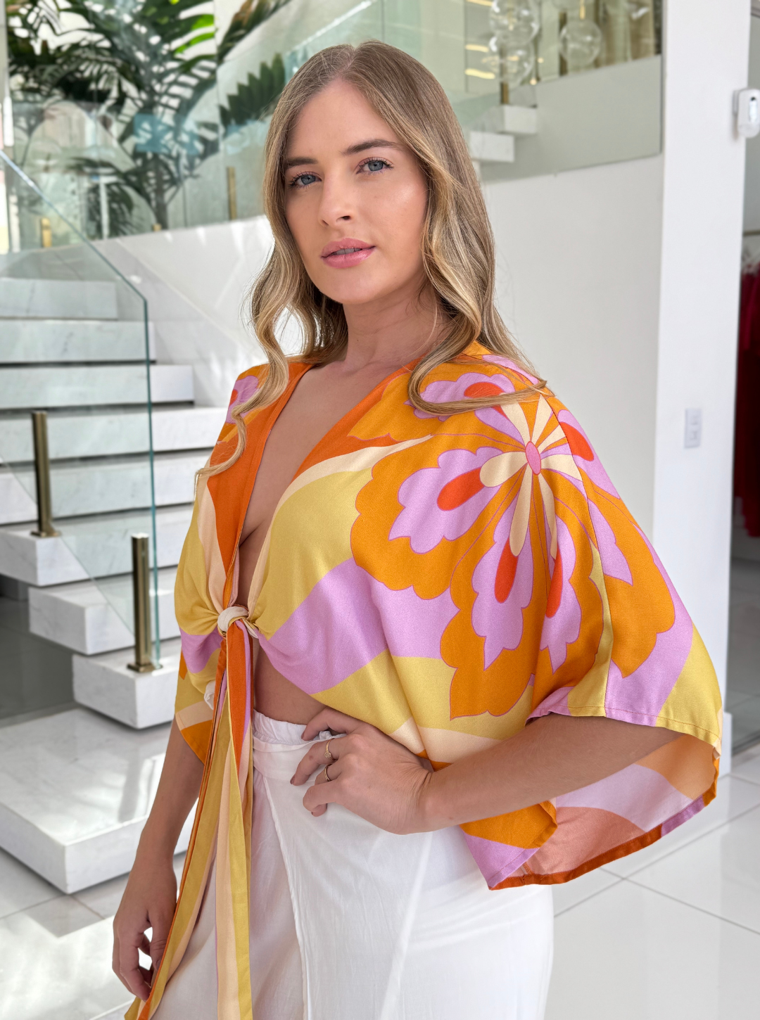 Colorful Blusa Aurora by FARM featuring a floral pattern and short sleeves on a white background.