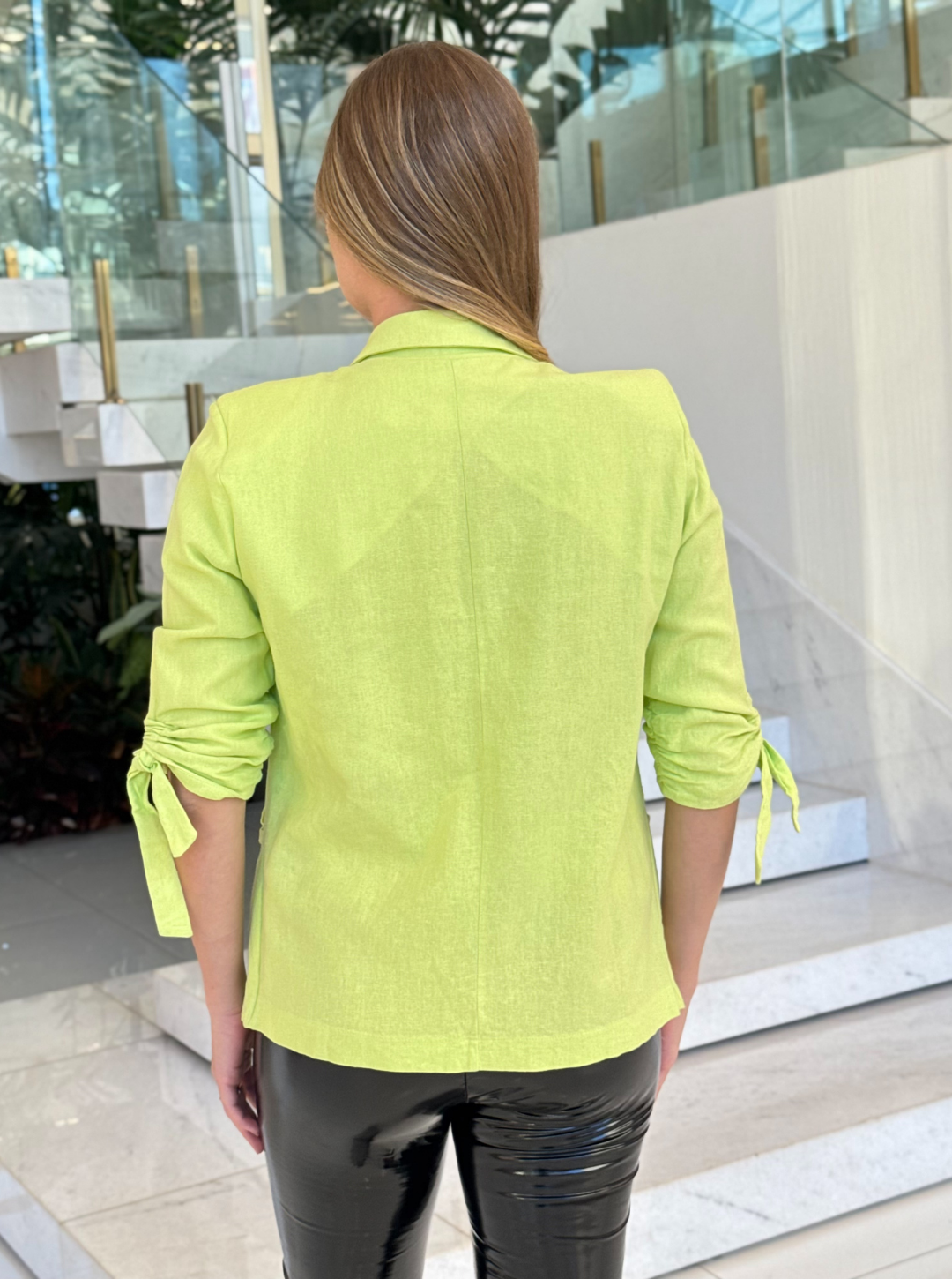 Blazer de linho verde Ísis da marca Lopz, modelo com corte clássico e detalhes elegantes, usado por uma mulher.