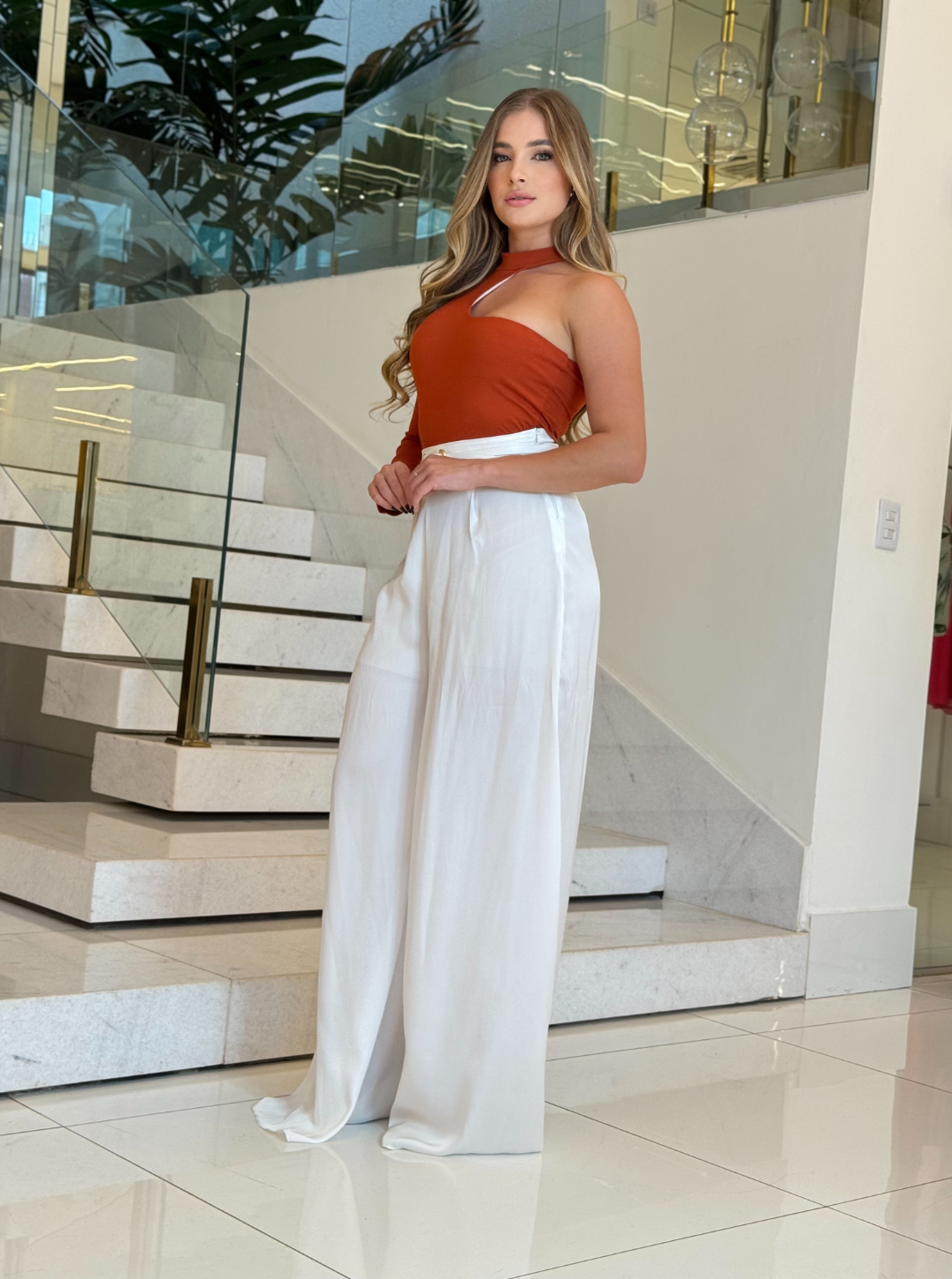 Corpo Laura Vitti Lopz em terracota, veste body ajustado com detalhes femininos, modelo de frente em fundo branco