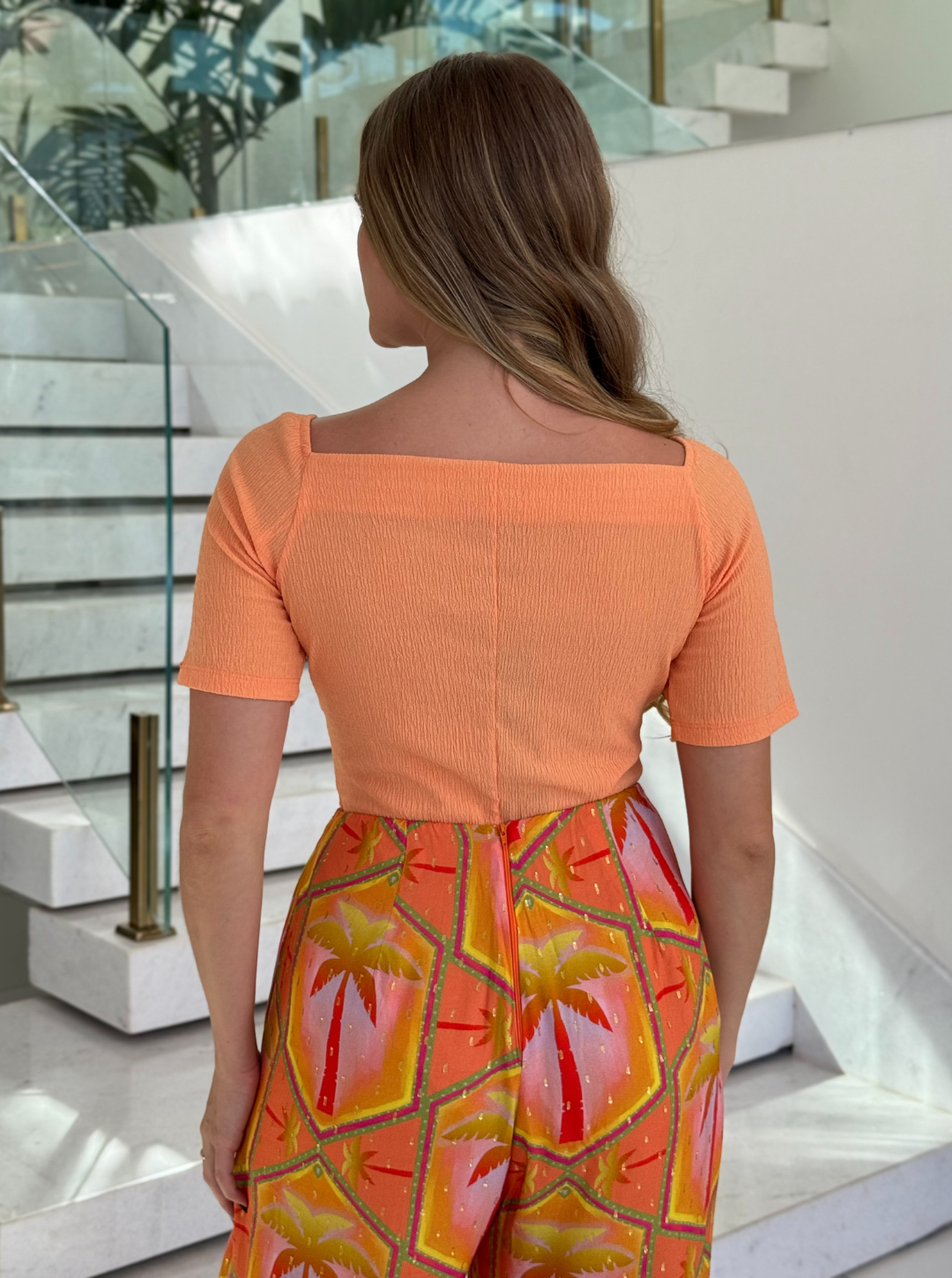 Corpo feminino Lopz Body Jessie Laranja, tecido ajustado, com detalhes de design em tom vibrante.