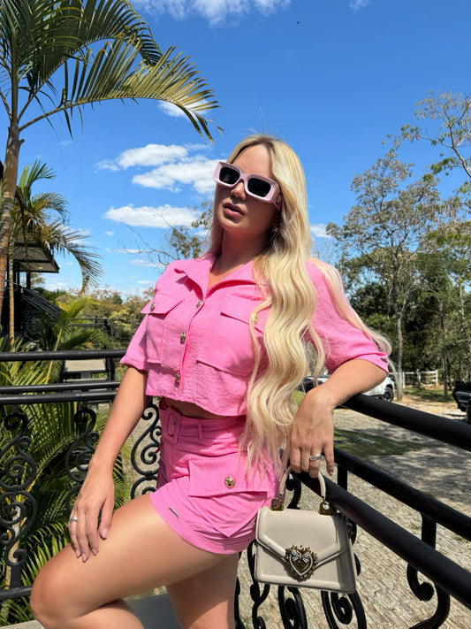 Cropped short sleeve pink shirt by Wanessa Lopez Concept displayed on a hanger against a neutral background.