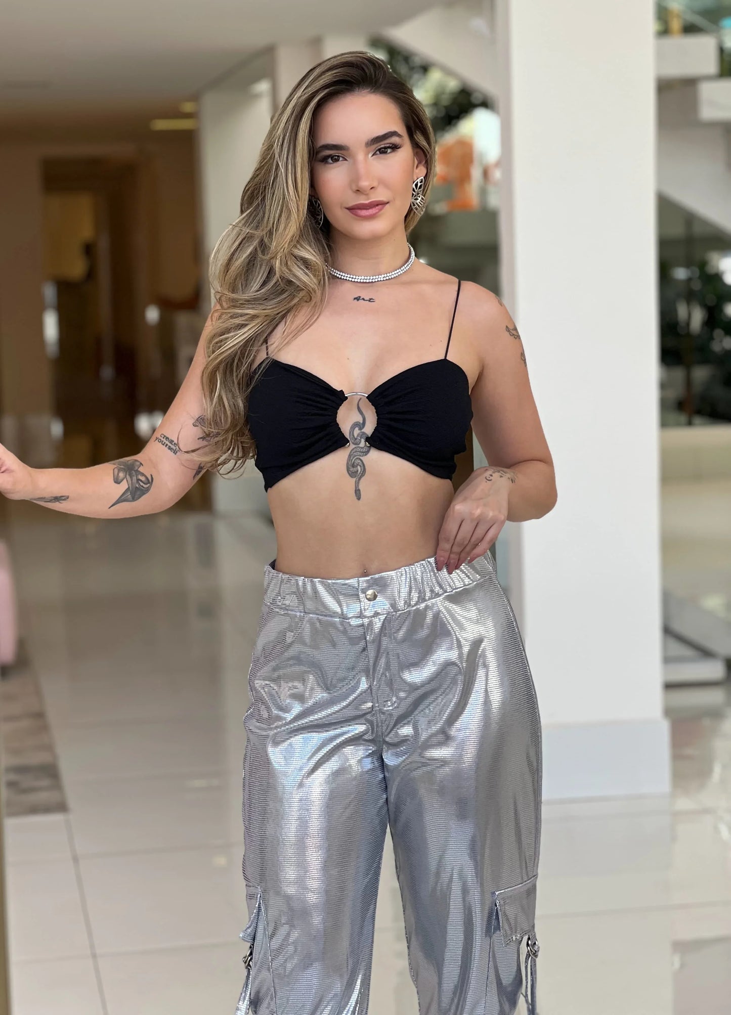 Calça metalizada prata Lopz, estilo moderno e elegante, com acabamento brilhante e cintura ajustada, ideal para looks fashion.