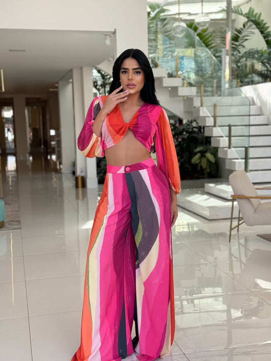 Blusa estampada com detalhes torcidos da marca Wanessa Lopez Concept em fundo neutro, destacando suas cores vibrantes.